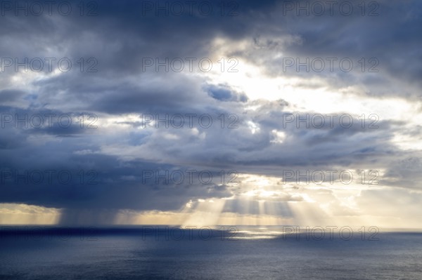 Sunset, sun rays over sea, dark rain cloud, rain, Madeira, Portugal
