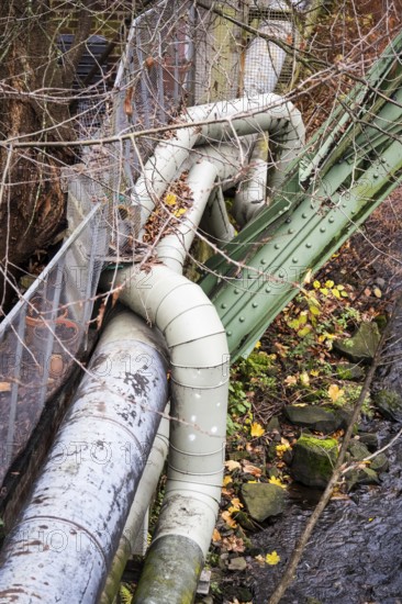 District heating pipeline in front of old industrial buildings on the banks of the Wupper, Wuppertal, Germany