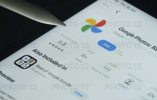 Dhaka, Bangladesh- 30 Oct 2025: Google Photos app on a iPad screen with a pen pointing at the install option