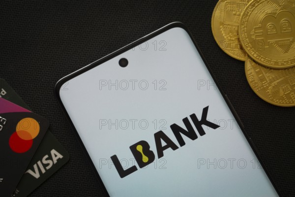 Dhaka, Bangladesh- 06 Sep 2025: Smartphone displaying Lbank logo surrounded by Bitcoin coins and payment cards