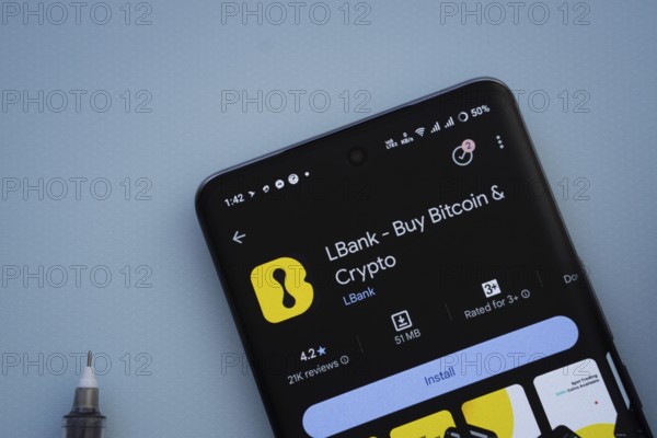 Dhaka, Bangladesh- 29 May 2025: On a blue surface, a smartphone displays the LBank app within the Google Play Store