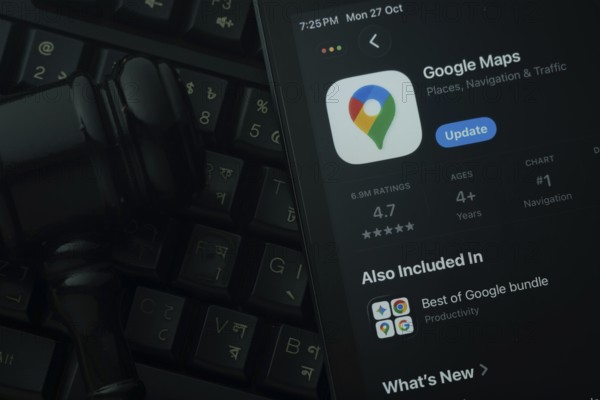 Dhaka, Bangladesh- 28 Oct 2025: An iPad displaying the Google Maps app against a judge's gavel and dark keyboard background