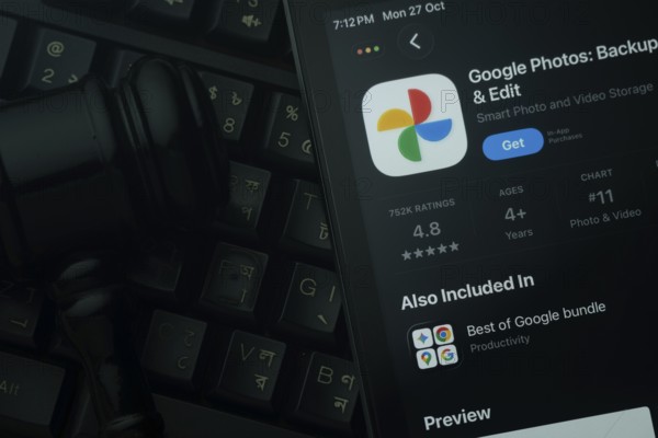 Dhaka, Bangladesh- 28 Oct 2025: An iPad displaying the Google Photos app against a judge's gavel and dark keyboard background
