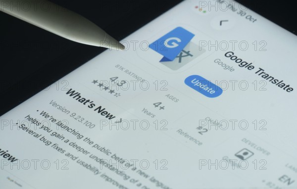 Dhaka, Bangladesh- 30 Oct 2025: Google Translate app on a iPad screen with a pen pointing at the install option