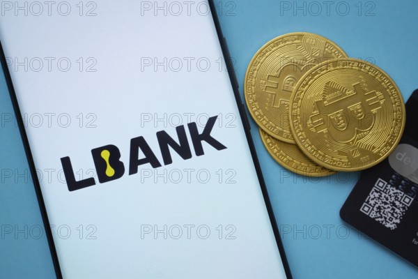 Dhaka, Bangladesh- 03 Sep 2025: Lbank logo on smartphone screen near Bitcoin coin and QR code on blue background