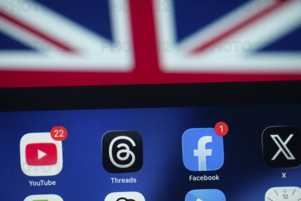 Dhaka, Bangladesh- 01 Dec 2025: A smartphone screen displays the Facebook, Youtube, X, Threads app with an UK flag in the background