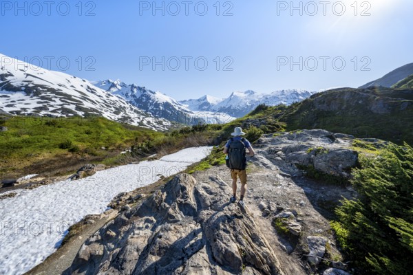 Hikers on the Portage Pass Trail, snow-covered mountains and Portage Glacier glaciers, near Whittier, Alaska, USA