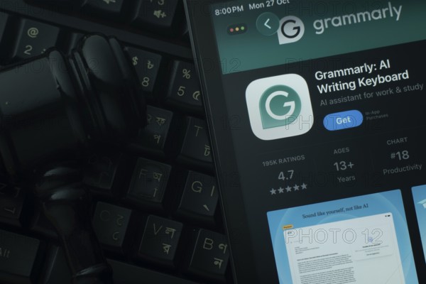 Dhaka, Bangladesh- 28 Oct 2025: An iPad displaying the Grammarly app against a judge's gavel and dark keyboard background