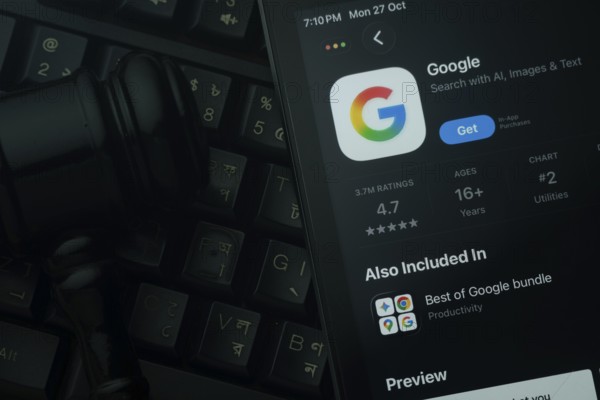 Dhaka, Bangladesh- 28 Oct 2025: An iPad displaying the Google app against a judge's gavel and dark keyboard background