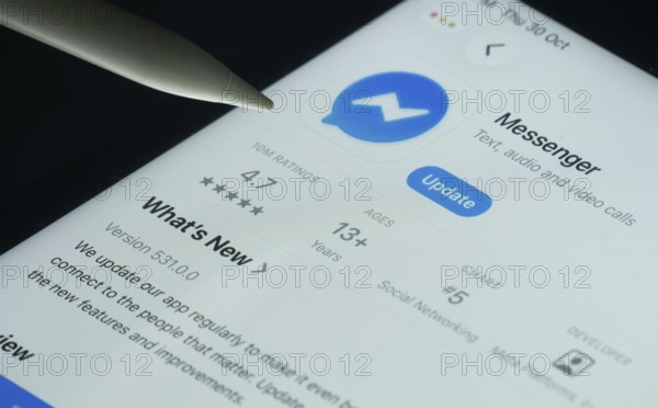 Dhaka, Bangladesh- 30 Oct 2025: Facebook Messenger app on a iPad screen with a pen pointing at the install option