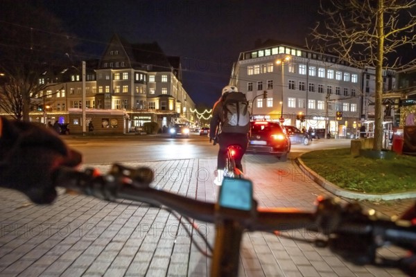 Cycling in the city, in the dark, in the evening, inner-city road, bicycle road, two-wheeler traffic has priority, 30 km/h zone, cyclist perspective, Essen, North Rhine-Westphalia, Germany