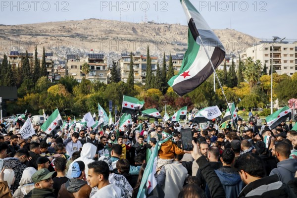 Damascus, Syria. November 28, 2025: Thousands of Syrians gather in Umayyad Square in central Damascus to celebrate the anniversary of the military operation that led to the fall of Bashar al-Assad's regime. Demonstrators express joy and unity while denouncing Israeli attacks on Syrian territory, Damascus, Damascus, Syria