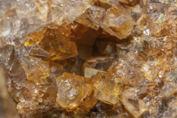 Shiny crystals of blue and orange color can be seen in this mineral formation. They are sparkling and show interesting textures in a natural setting