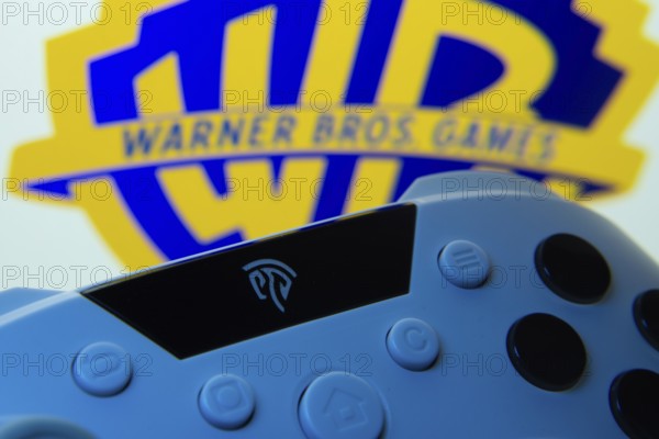 Dhaka, Bangladesh- 14 Nov 2025: A close-up of a gamepad with the Warner Bros. Games seen on screen in the background