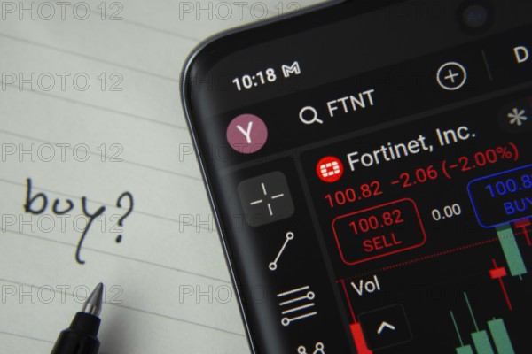 Dhaka, Bangladesh- 20 June 2025: Fortinet Inc stock trading details displayed on smartphone with handwritten note