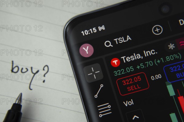 Dhaka, Bangladesh- 20 June 2025: Tesla Inc stock trading details displayed on smartphone with handwritten note