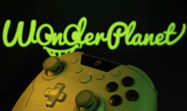 Dhaka, Bangladesh- 14 Nov 2025: A close-up of a gamepad with the WonderPlanet Inc seen on screen in the background