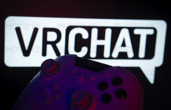 Dhaka, Bangladesh- 14 Nov 2025: A close-up of a gamepad with the VRChat seen on screen in the background