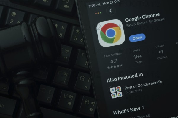 Dhaka, Bangladesh- 28 Oct 2025: An iPad displaying the Google Chrome app against a judge's gavel and dark keyboard background