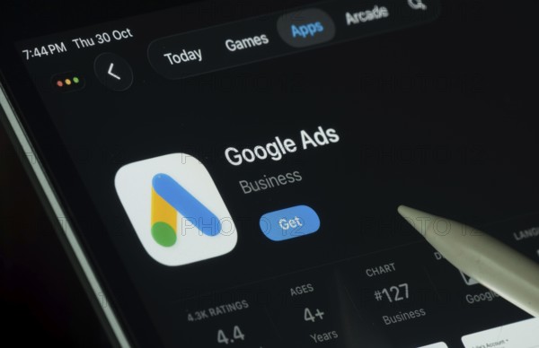 Dhaka, Bangladesh- 30 Oct 2025: Google Ads app displayed on a iPad screen in dark mode with a digital pen pointing at it