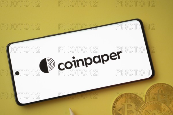 Dhaka, Bangladesh- 19 Sep 2025: Coinpaper logo on smartphone screen near Bitcoin coin and QR code on background