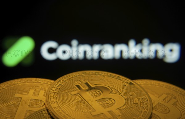 Dhaka, Bangladesh- 19 Sep 2025: Close-up of Bitcoin coins with the Coinranking logo visible on a screen in the background