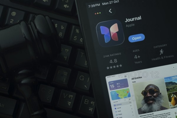 Dhaka, Bangladesh- 28 Oct 2025: An iPad displaying the Apple Journal app against a judge's gavel and dark keyboard background