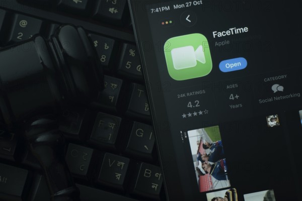 Dhaka, Bangladesh- 28 Oct 2025: An iPad displaying the Apple Facetime app against a judge's gavel and dark keyboard background
