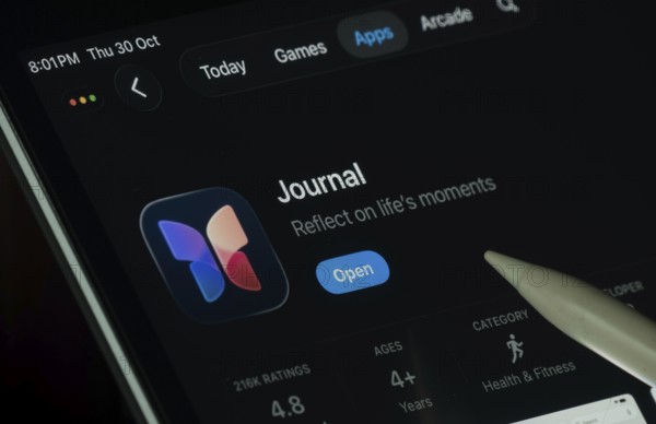 Dhaka, Bangladesh- 30 Oct 2025: Apple Journal app displayed on a iPad screen in dark mode with a digital pen pointing at it