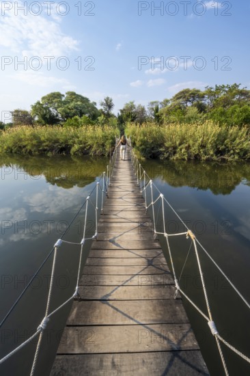 Toruist on the Kavango River, suspension bridge at Camp Kwando, Zambezi region, Caprivi Strip, Namibia