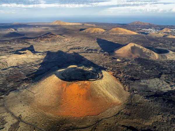 Caldera Colorada volcano, picturesque volcanic landscape with volcanic craters and lava fields in morning light, Parque Natural de Los Volcanes, aerial view, Lanzarote, Canary Islands, Spain