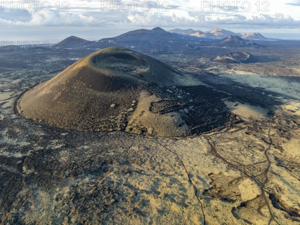 Montaña Negra volcano, picturesque volcanic landscape with volcanic craters and lava fields in morning light, Parque Natural de Los Volcanes, aerial view, Lanzarote, Canary Islands, Spain