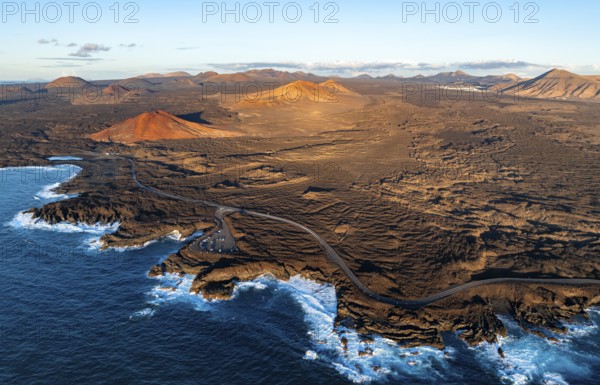 Coast with lava fields, volcanic landscape near Los Hervideros with red volcano Montaña Bermeja, in the evening light, aerial view, Lanzarote, Canary Islands, Spain