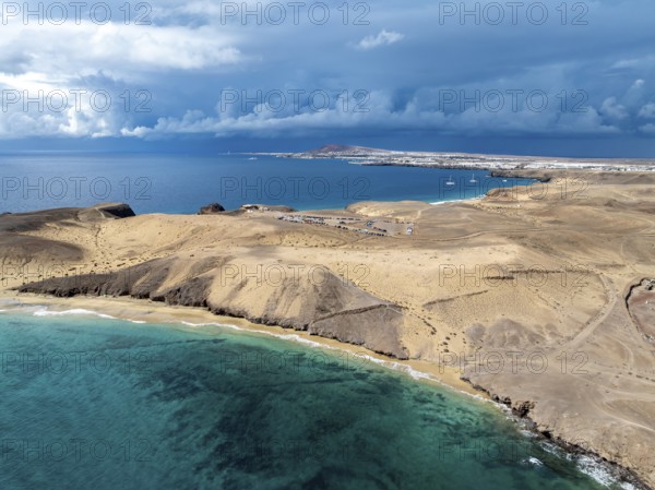 Coast with Playa Caleta del Congrio beach and blue sea, arid landscape of Los Ajaches Natural Park, aerial view, Lanzarote, Canary Islands, Spain