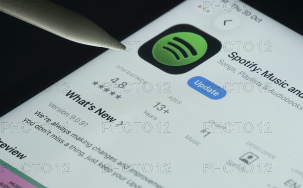 Dhaka, Bangladesh- 30 Oct 2025: Spotify app on a iPad screen with a pen pointing at the install option