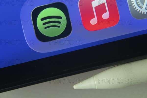 16 Nov 2025- Dhaka, Bangladesh: Spotify and Apple Music and other app icons with a digital pen on a iPad screen