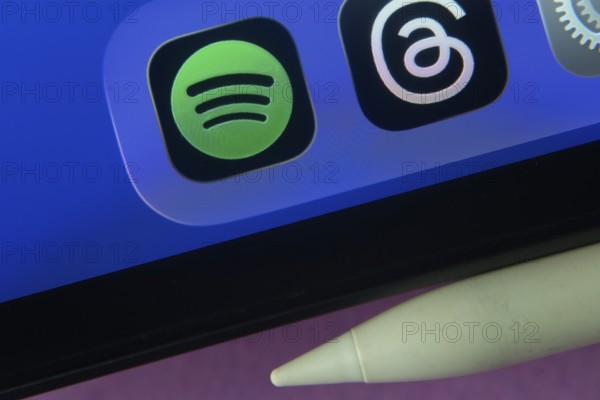 16 Nov 2025- Dhaka, Bangladesh: Spotify and other app icons with a digital pen on a iPad screen