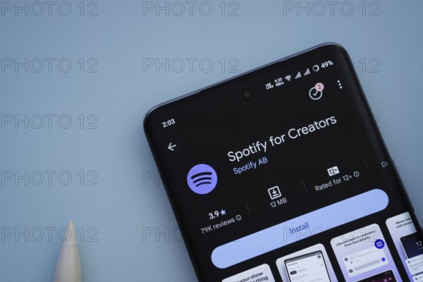 Dhaka, Bangladesh- 29 May 2025: On a blue surface, a smartphone displays the Spotify for Creators app within the Google Play Store