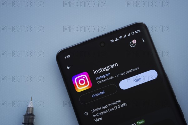 Dhaka, Bangladesh- 29 May 2025: On a blue surface, a smartphone displays the Instagram app within the Google Play Store