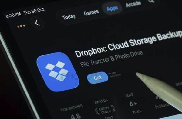 Dhaka, Bangladesh- 30 Oct 2025: Dropbox app displayed on a iPad screen in dark mode with a digital pen pointing at it