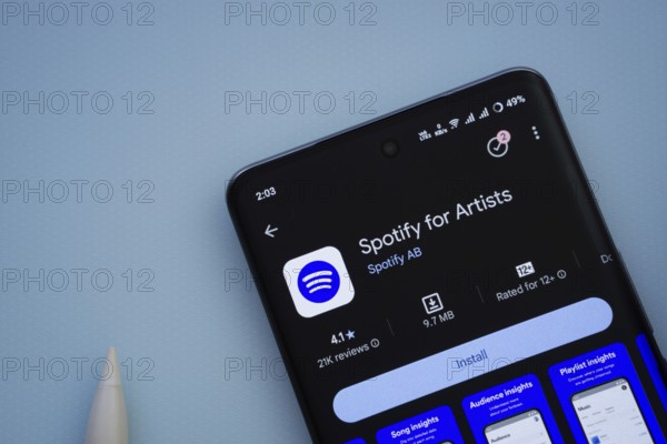 Dhaka, Bangladesh- 29 May 2025: On a blue surface, a smartphone displays the Spotify for Artists app within the Google Play Store