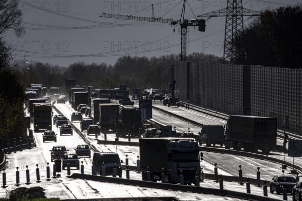 Highway construction site, the A57 is extended to 6 lanes on the section between the Meerbusch motorway junction and the Oppum junction, traffic runs parallel to 2 narrowed lanes, wet road after rain shower, Krefeld, North Rhine-Westphalia, Germany