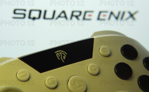 Dhaka, Bangladesh- 14 Nov 2025: A close-up of a gamepad with the Square Enix seen on screen in the background
