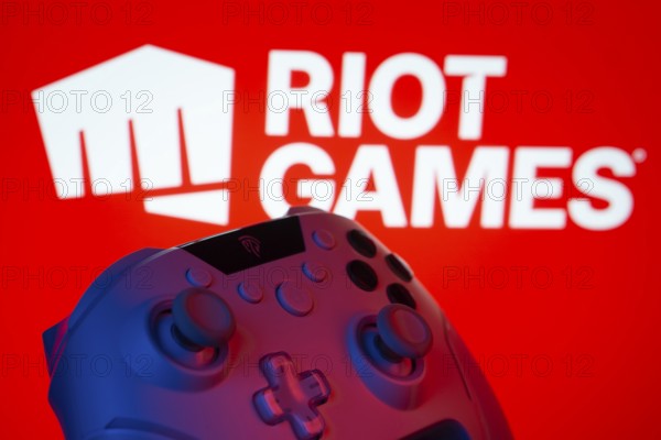 Dhaka, Bangladesh- 14 Nov 2025: A close-up of a gamepad with the Riot Games seen on screen in the background