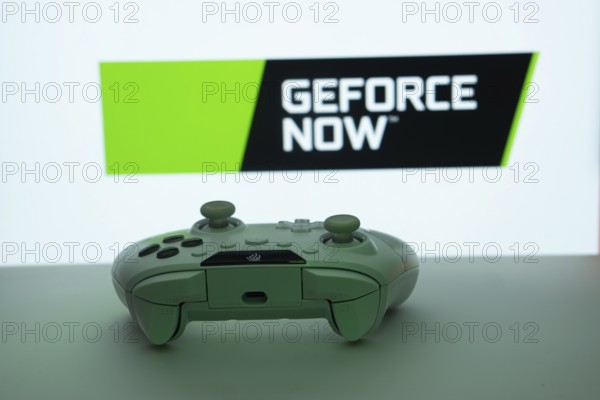 Dhaka, Bangladesh- 14 Nov 2025: A close-up of a white gamepad with the Geforce Now seen on screen in the background