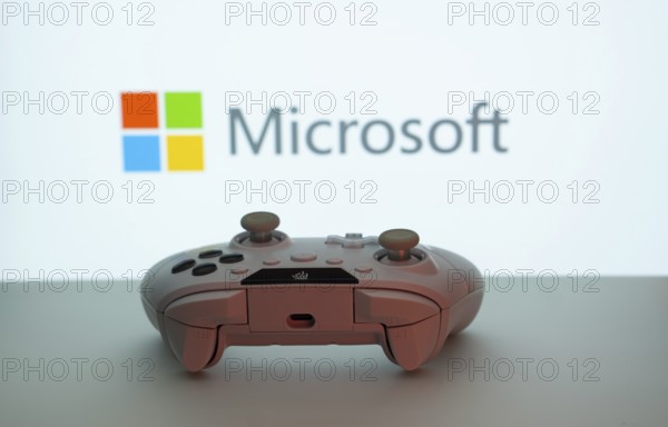 Dhaka, Bangladesh- 09 May 2025: A close-up of a white gamepad with the Microsoft seen on screen in the background