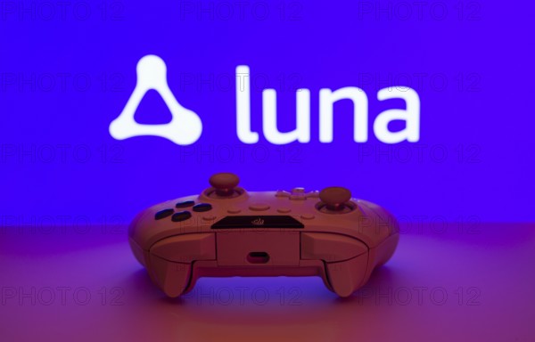 Dhaka, Bangladesh- 14 Nov 2025: A close-up of a white gamepad with the Amazon Luna seen on screen in the background