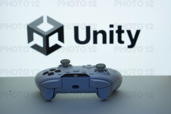 Dhaka, Bangladesh- 14 Nov 2025: A close-up of a white gamepad with the Unity seen on screen in the background