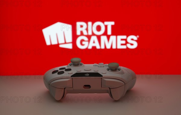 Dhaka, Bangladesh- 14 Nov 2025: A close-up of a white gamepad with the Riot Games seen on screen in the background