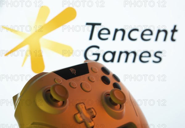 Dhaka, Bangladesh- 14 Nov 2025: A close-up of a gamepad with the Tencent Games seen on screen in the background